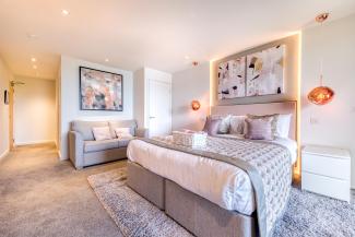 The interior of and executive sea view room with balcony at Sandy Cove Hotel showing the bed and seating area