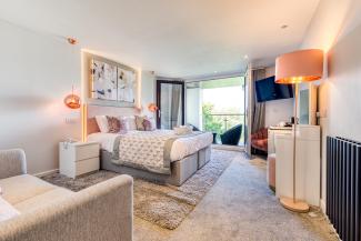 The interior of and executive sea view room with balcony at Sandy Cove Hotel showing the bed and balcony