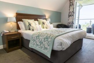 The bed inside a Superior Sea View with Balcony room at Sandy Cove Hotel