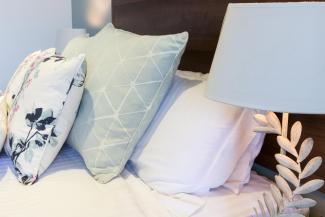 Cushions and pillows on the bed inside a Superior Sea View with Balcony room at Sandy Cove Hotel