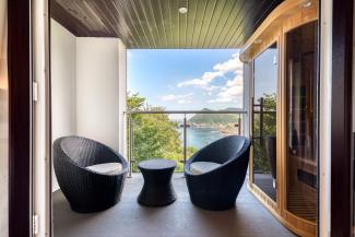 The balcony with nest egg chairs and infrared sauna in one of the executive sea view rooms at Sandy Cove hotel
