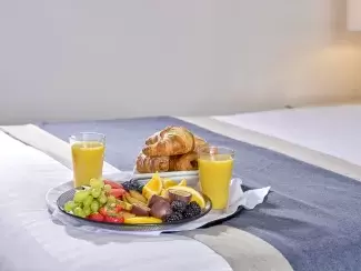 A breakfast tray on the bed in a classic room at Sandy Cove Hotel