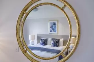 A mirror in one of Sandy Cove Hotel's classic rooms with the bed showing in the reflection