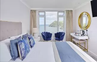 The interior of a classic room at Sandy Cove Hotel showing the view over the bay from the window